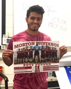 Matthew Vega (Morton West, Class of 2016) displays the soccer poster he created. This is the second poster by Vega selected for publication by the Athletics Department.