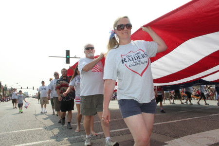 Members of the Oak Lawn Raiders Social Athletic Club carry the American Flag in the parade
