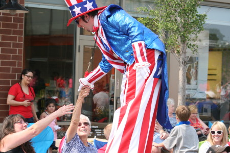 Man on stilts greets guests at parade