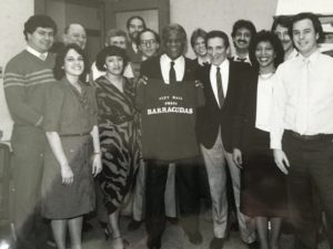 Mayor Harold Washington with the City Hall reporters in 1985 holding up a t-shirt he printed for the reporter baseball team The Barracudas